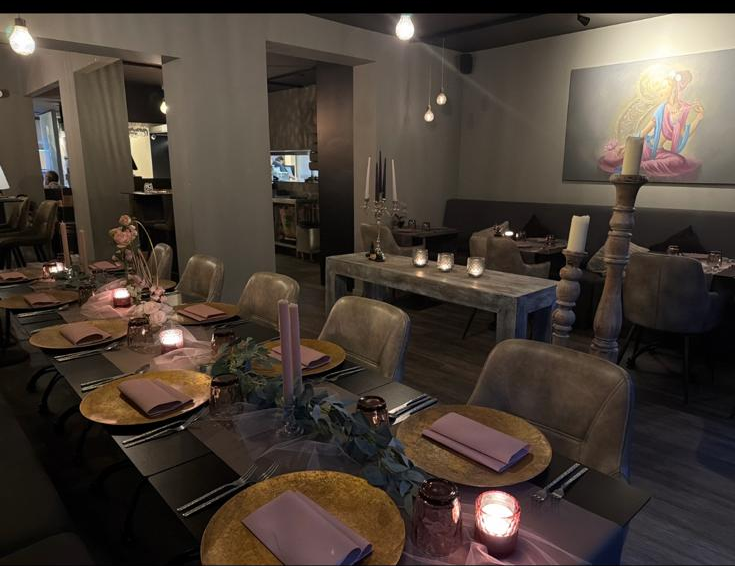 Interieur van The Buddha Lounge bij avond — gedekte tafel met kaarsen
